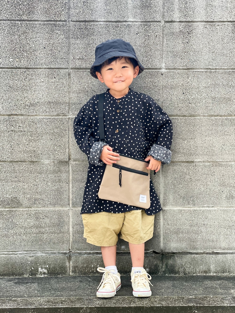 グレー系のシャツ/ブラウス、ベージュ系のパンツ、ホワイト系のスニーカーを着用したキッズの秋コーディネートの2枚目の写真