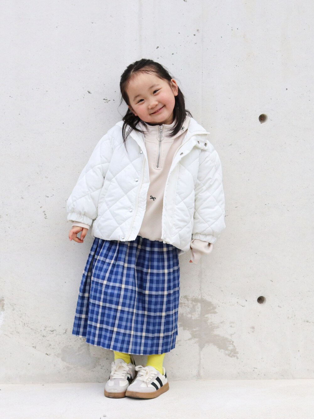 ベージュ系のブルゾン、ホワイト系のパーカー、その他のスカートを着用したキッズの冬コーディネートの2枚目の写真