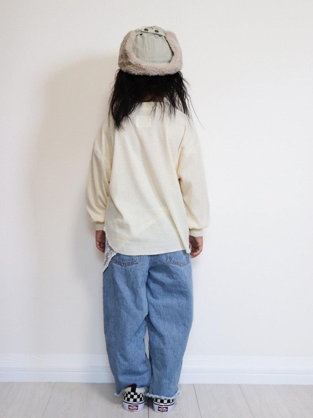 ホワイト系のTシャツ/カットソー、ブルー系のデニムパンツ、ブラック系のスニーカーを着用したキッズの秋コーディネートの3枚目の写真