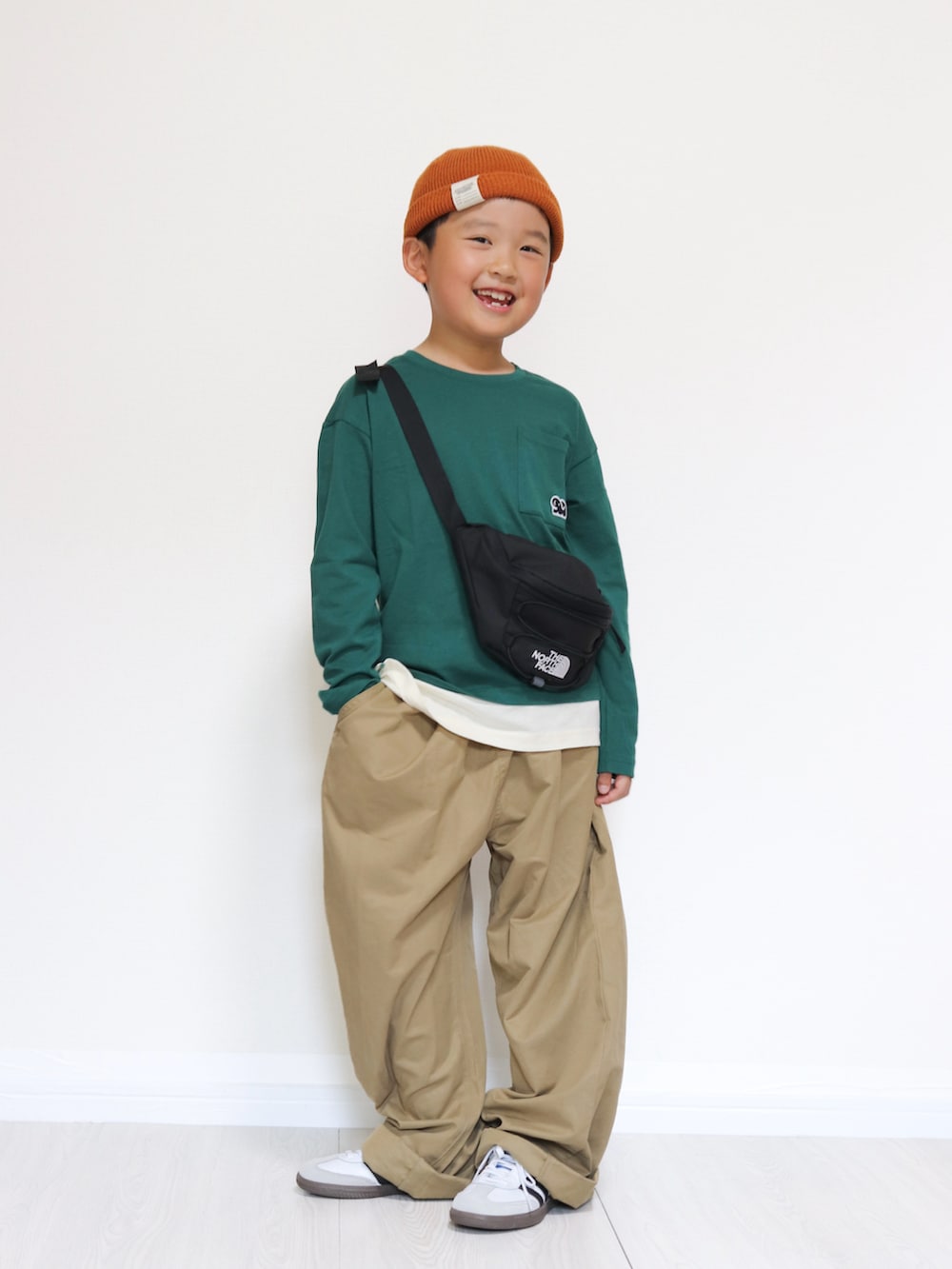 ホワイト系のスニーカー、グリーン系のTシャツ/カットソー、ベージュ系のその他パンツを着用したキッズの秋コーディネートの2枚目の写真