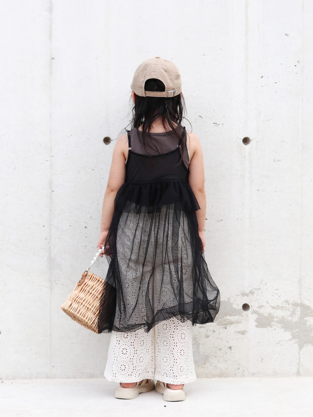 グレー系のタンクトップ、ホワイト系のその他パンツ、ブラック系のワンピースを着用したキッズの夏コーディネートの4枚目の写真