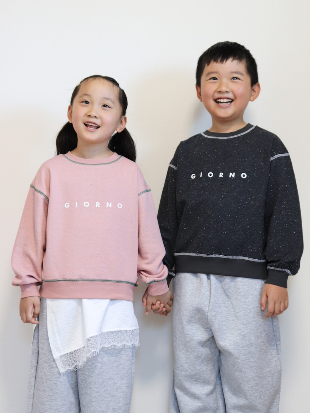 ピンク系のパーカー、ホワイト系のTシャツ/カットソー、グレー系のスウェットパンツを着用したキッズの秋コーディネートの4枚目の写真