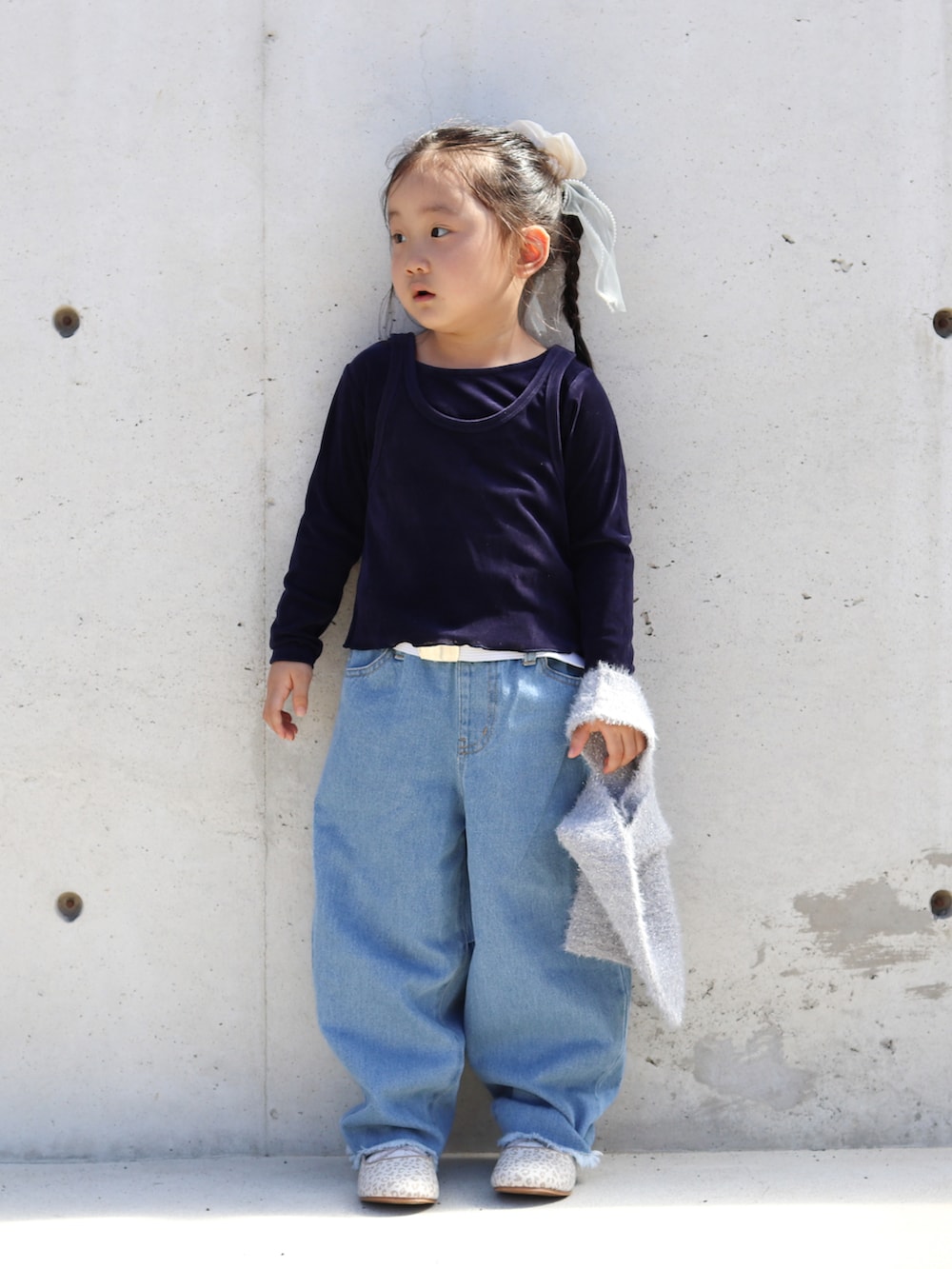 ブルー系のTシャツ/カットソー、ブルー系のデニムパンツ、ベージュ系のバレエシューズを着用したキッズの秋コーディネートの4枚目の写真