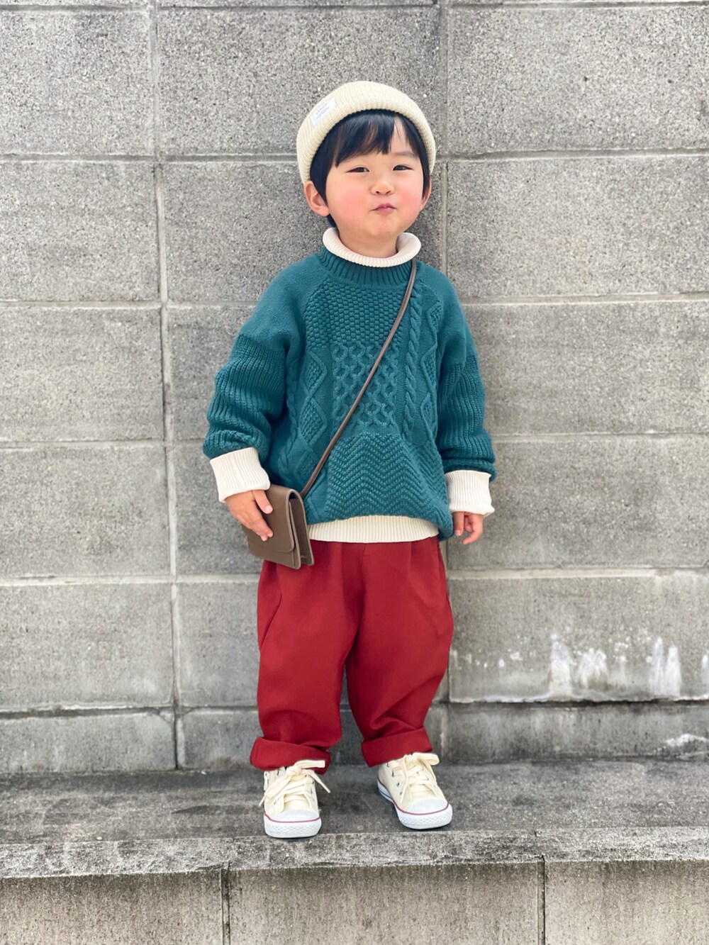 グリーン系のニット/セーター、ホワイト系のニット/セーター、レッド系のその他パンツを着用したキッズの冬コーディネートの3枚目の写真
