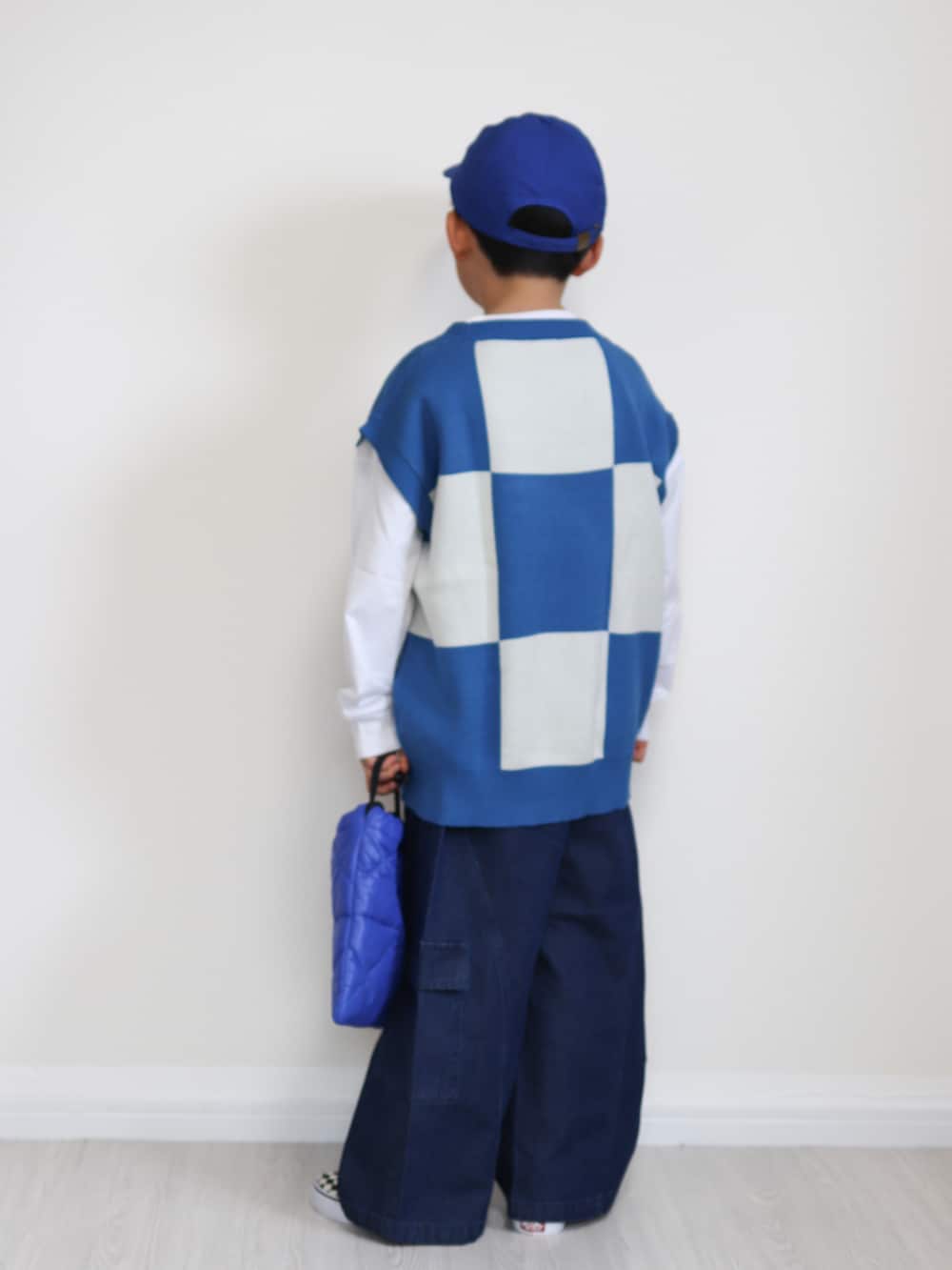 ブルー系のベスト、ブルー系のその他パンツ、ブルー系のショルダーバッグを着用したキッズの冬コーディネートの5枚目の写真