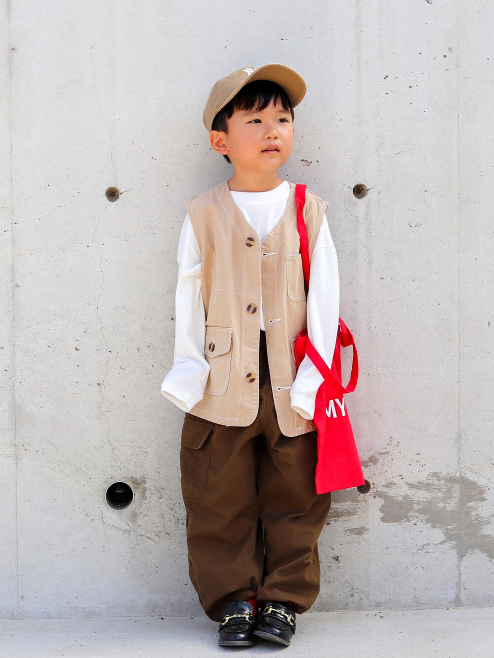 ホワイト系のTシャツ/カットソー、ベージュ系のベスト、ブラウン系のカーゴパンツを着用したキッズの秋コーディネートの3枚目の写真