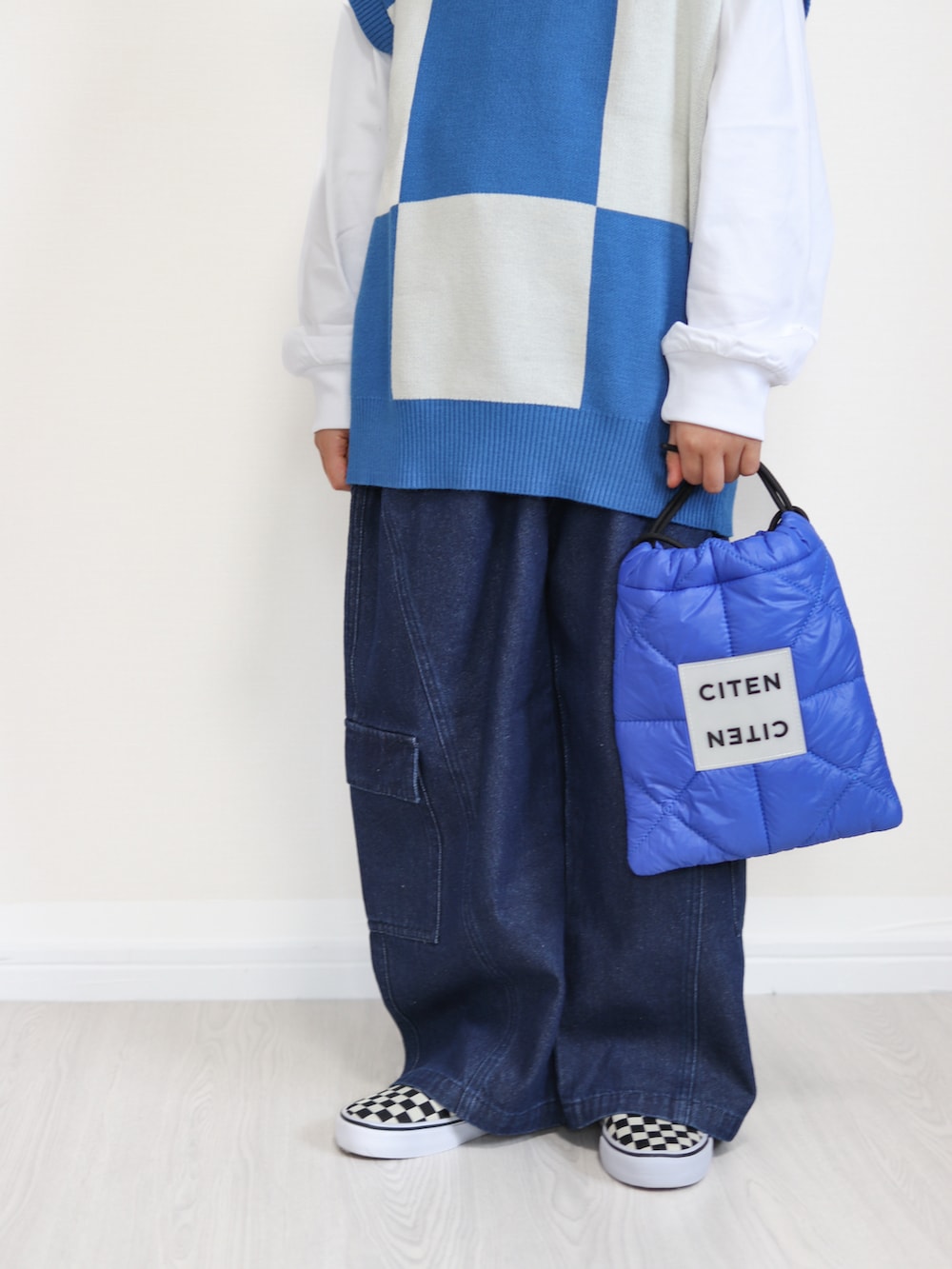 ブルー系のベスト、ブルー系のその他パンツ、ブルー系のショルダーバッグを着用したキッズの冬コーディネートの2枚目の写真