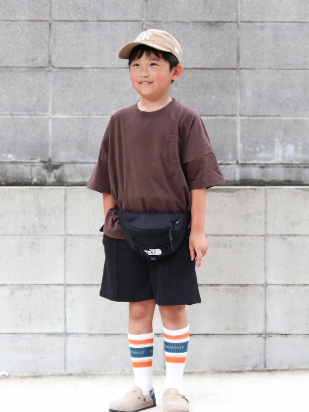 ブラウン系のTシャツ/カットソー、ブラック系のその他パンツ、ブラック系のボディバッグ/ウエストポーチを着用したキッズの夏コーディネートの2枚目の写真