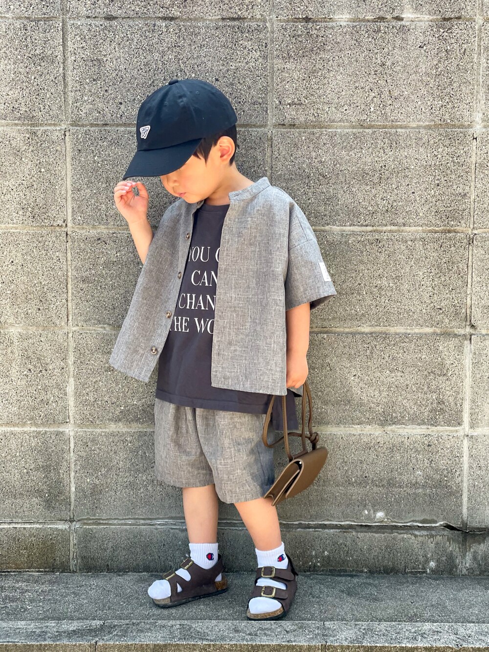 グレー系のトップス、グレー系のTシャツ/カットソー、ブラウン系のサンダルを着用したキッズの春コーディネートの2枚目の写真