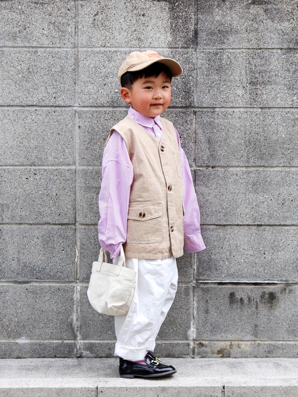 ピンク系のシャツ/ブラウス、ベージュ系のベスト、ホワイト系のその他パンツを着用したキッズの春コーディネートの3枚目の写真