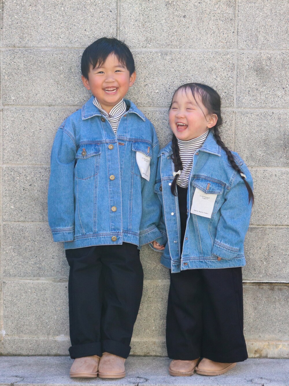 ブルー系のデニムジャケット、ホワイト系のトップス、ブラック系のサロペット/オーバーオールを着用したキッズの冬コーディネートの2枚目の写真