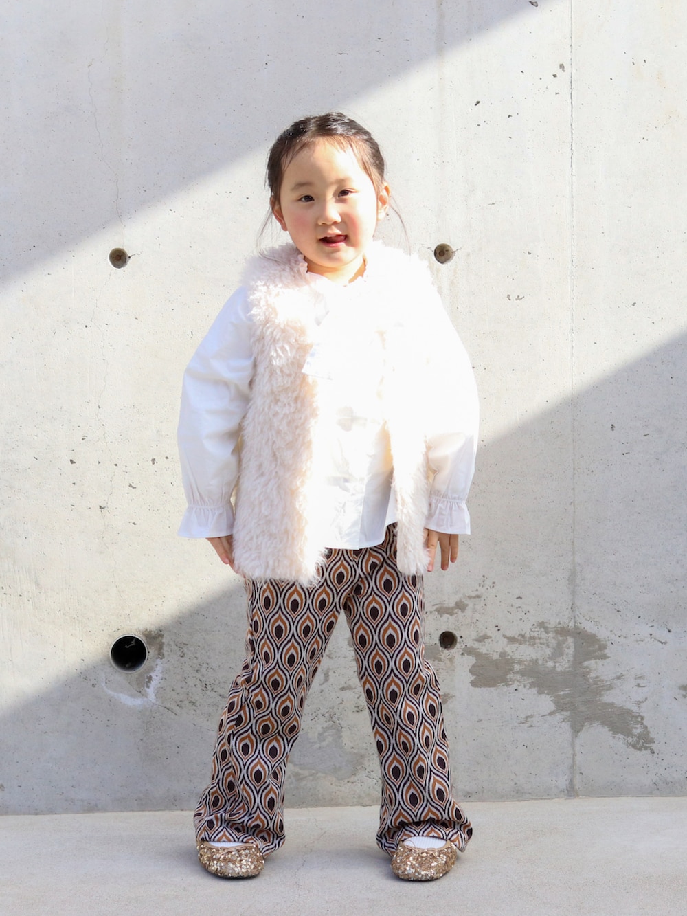 ホワイト系のシャツ/ブラウス、ホワイト系のベスト、ブラウン系のスウェットパンツを着用したキッズの冬コーディネートの2枚目の写真