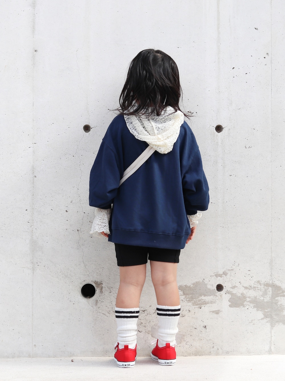 レッド系のスニーカー、ブルー系のスウェット、ホワイト系のTシャツ/カットソーを着用したキッズの秋コーディネートの3枚目の写真