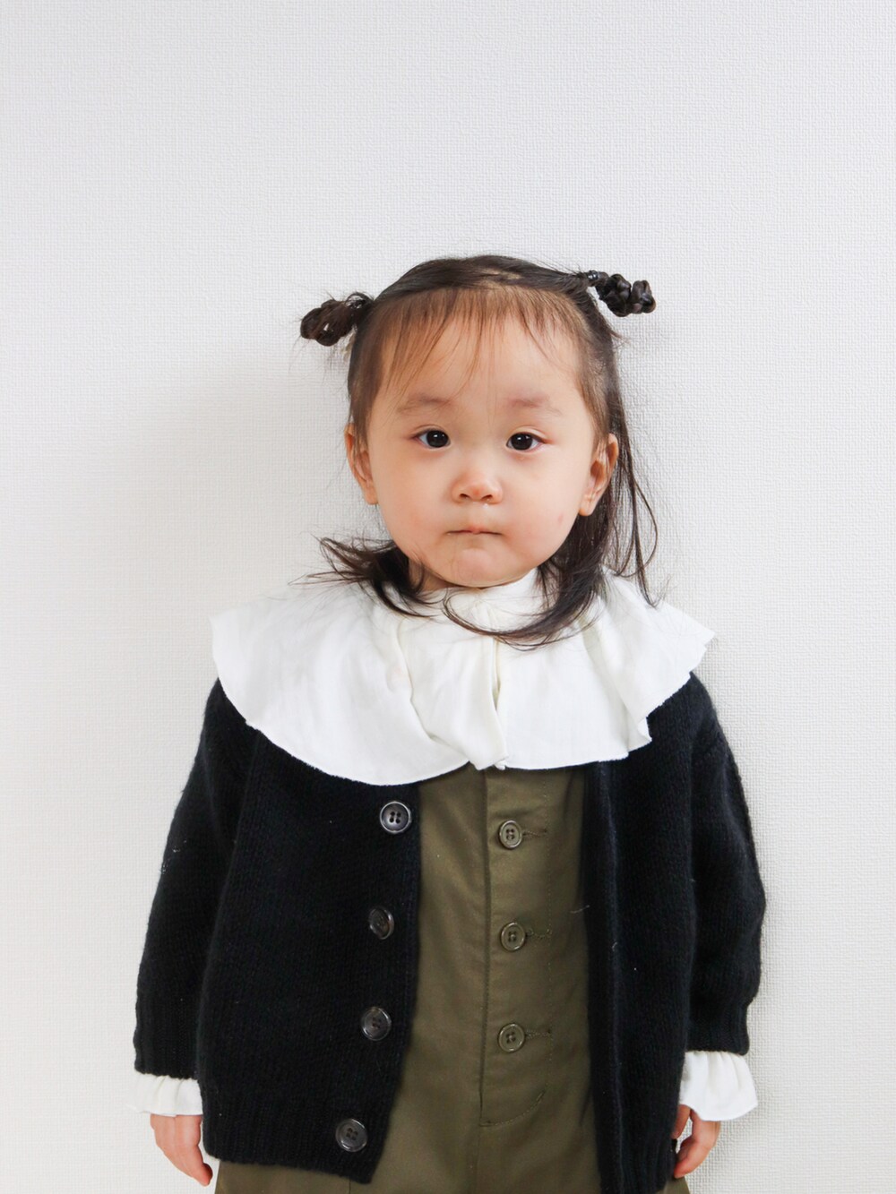 ブラック系のカーディガン/ボレロ、グリーン系のサロペット/オーバーオール、ホワイト系のシャツ/ブラウスを着用したキッズの秋コーディネートの4枚目の写真