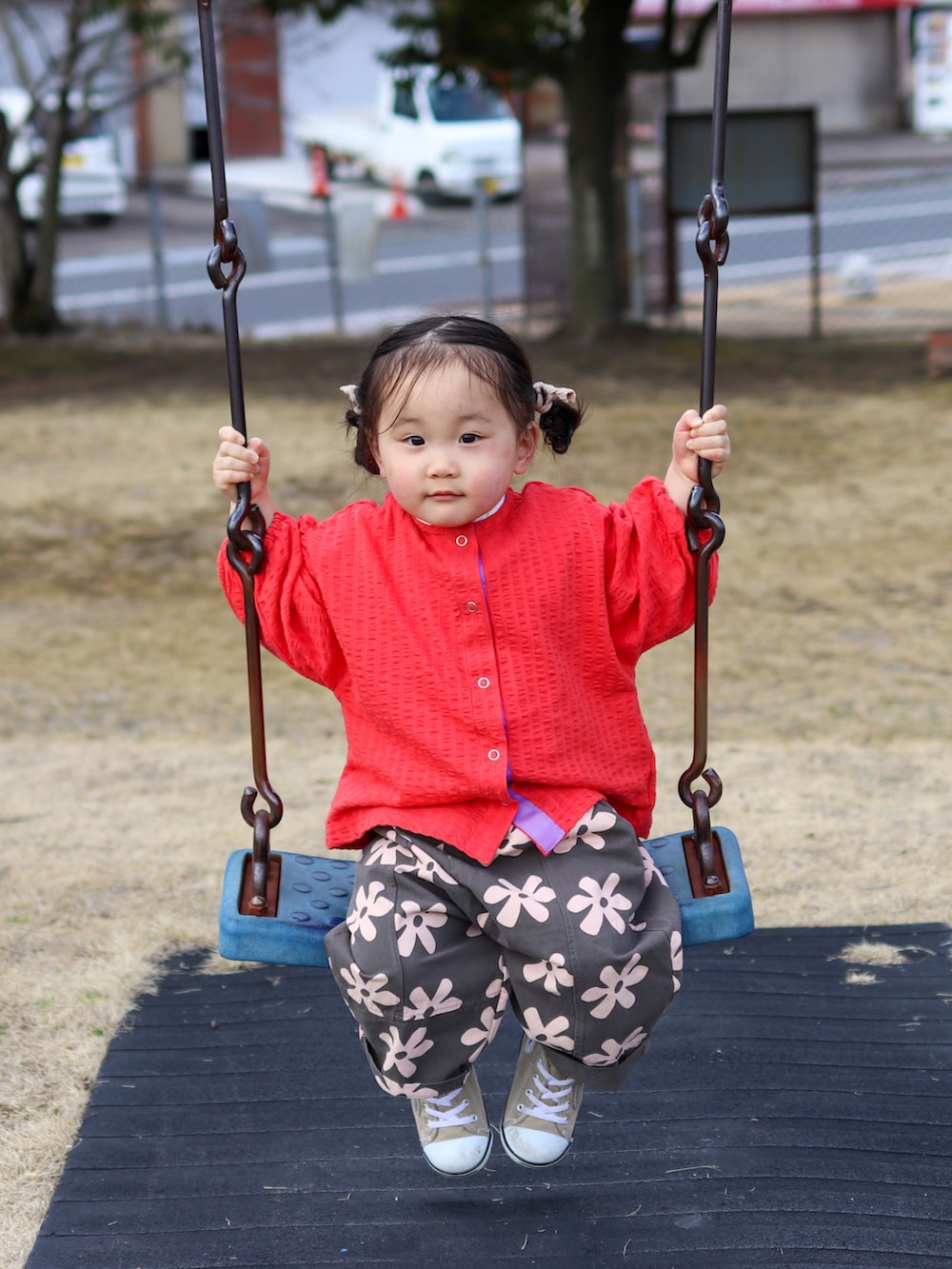 レッド系のカーディガン/ボレロ、グレー系のスラックス、ベージュ系のスニーカーを着用したキッズの春コーディネートの4枚目の写真