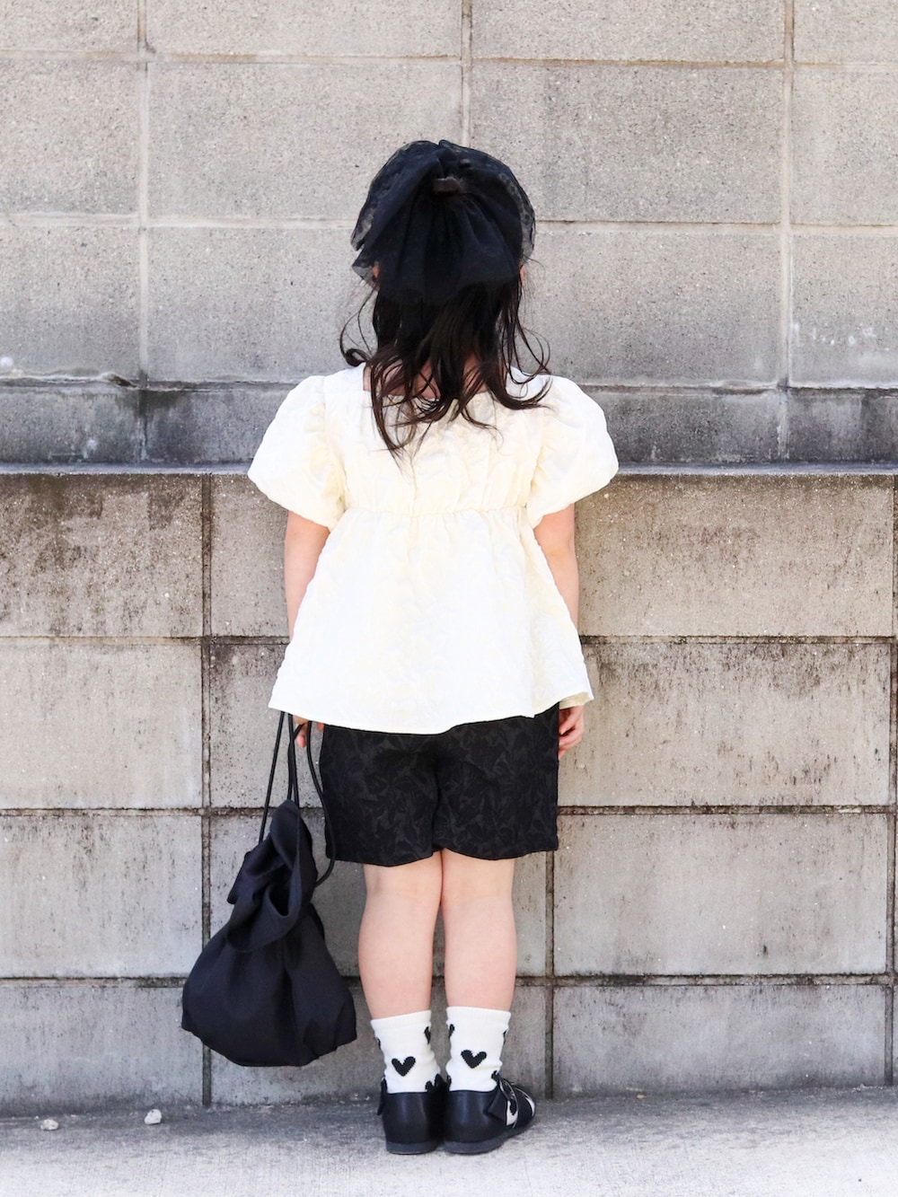 ホワイト系のシャツ/ブラウス、ブラック系のその他パンツ、ブラック系のサンダルを着用したキッズの春コーディネートの3枚目の写真