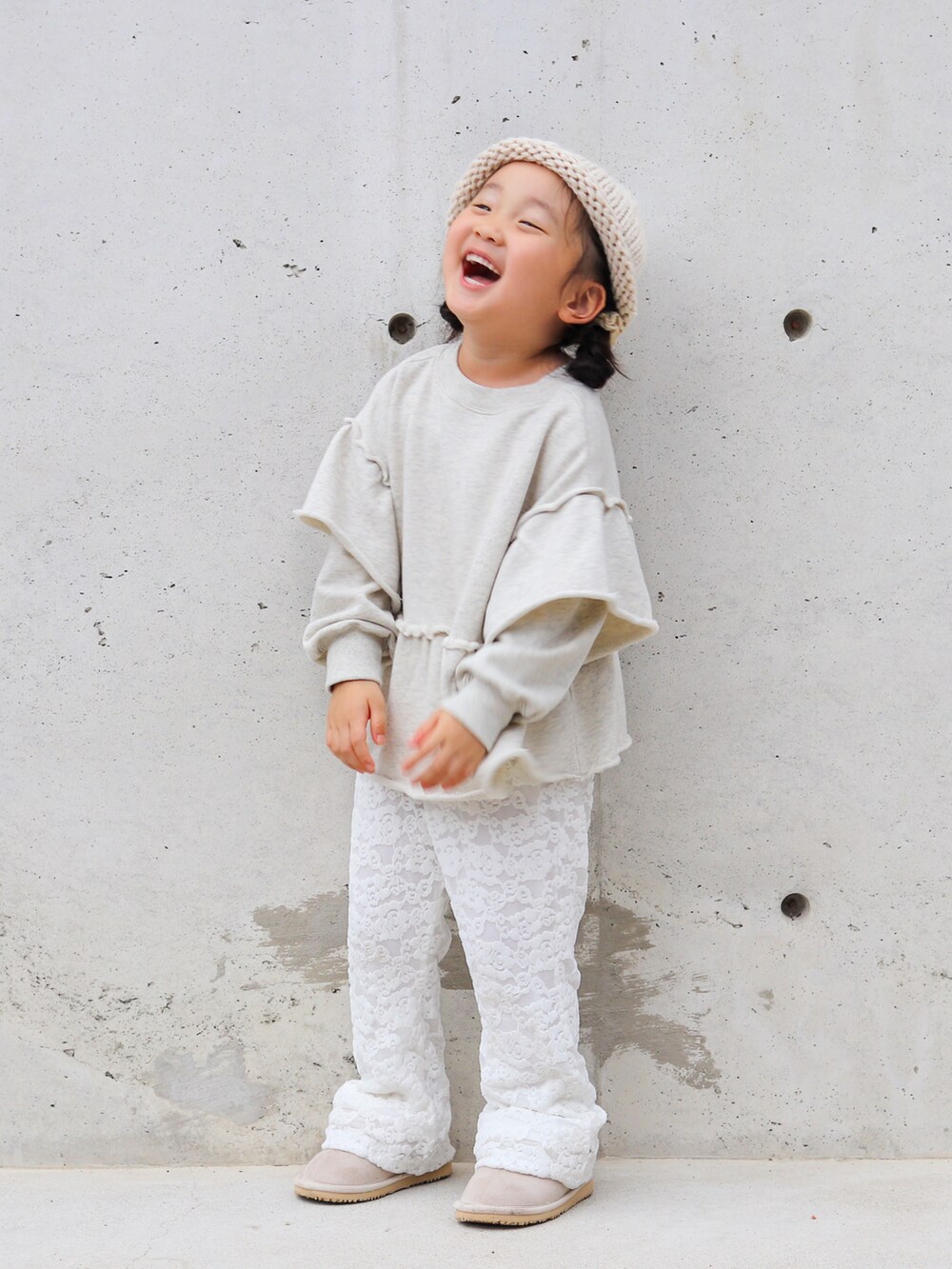 グレー系のスウェット、ホワイト系のその他パンツ、ベージュ系のブーツを着用したキッズの秋コーディネートの3枚目の写真