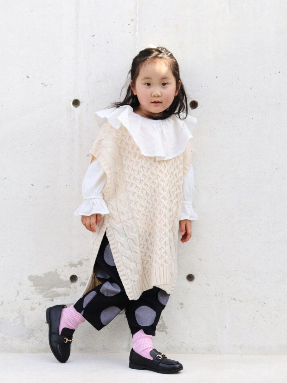 ホワイト系のTシャツ/カットソー、ベージュ系のベスト、ブラック系のその他パンツを着用したキッズの冬コーディネートの4枚目の写真