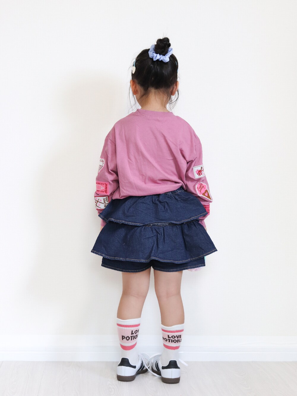 ホワイト系のスニーカー、ピンク系のTシャツ/カットソー、ブルー系のデニムパンツを着用したキッズの秋コーディネートの4枚目の写真