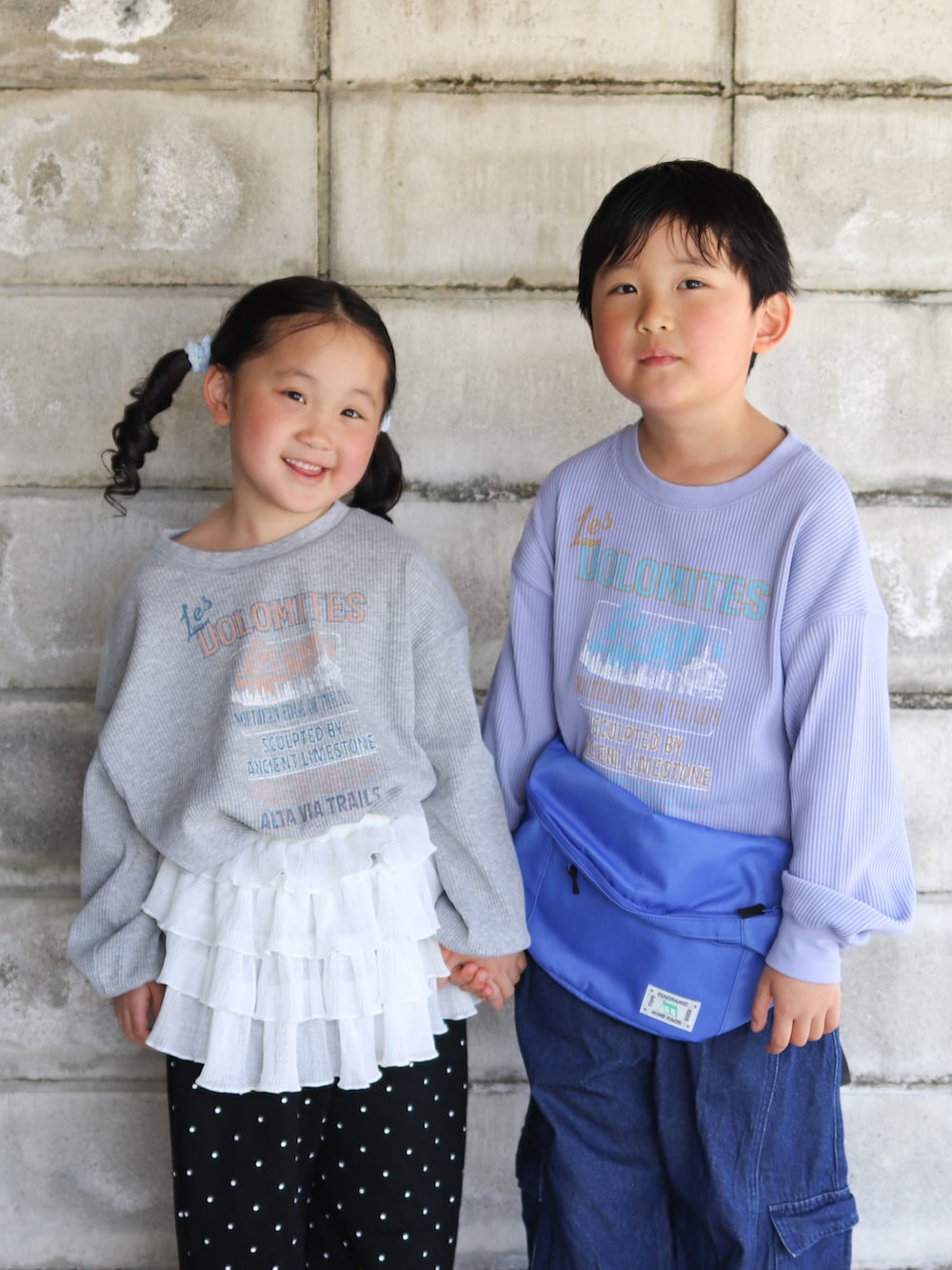 ブルー系のカーゴパンツ、ブルー系のボディバッグ/ウエストポーチ、ベージュ系のサンダルを着用したキッズの春コーディネートの2枚目の写真