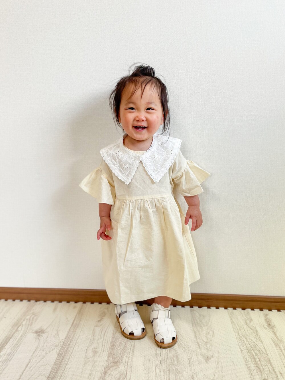 ホワイト系のワンピース、ホワイト系のサンダルを着用したキッズの春コーディネートの2枚目の写真
