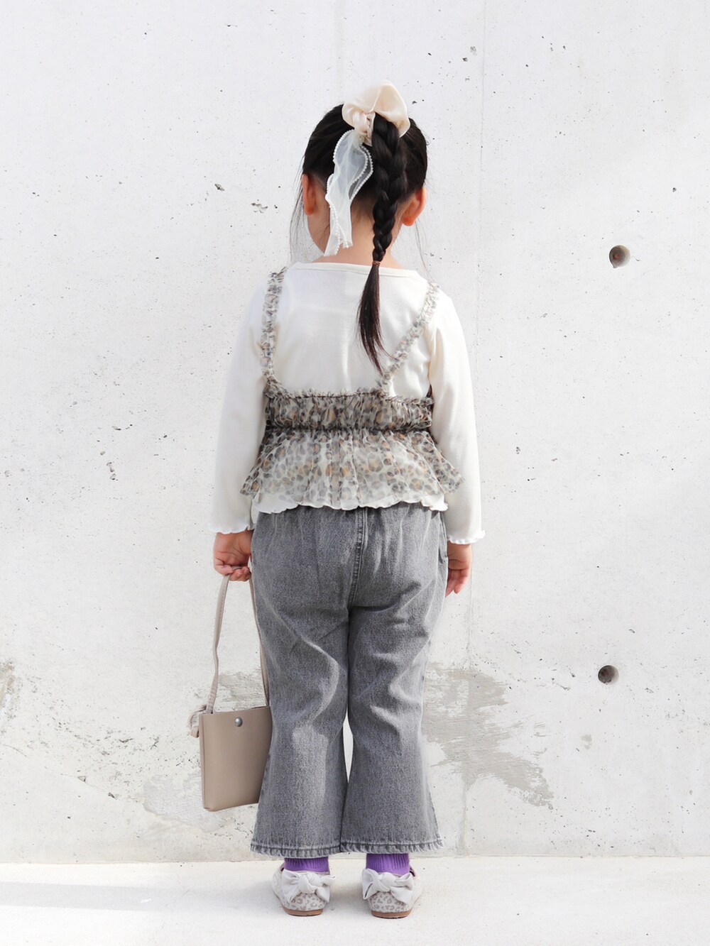 ホワイト系のTシャツ/カットソー、ブラック系のデニムパンツ、ベージュ系のバレエシューズを着用したキッズの冬コーディネートの3枚目の写真