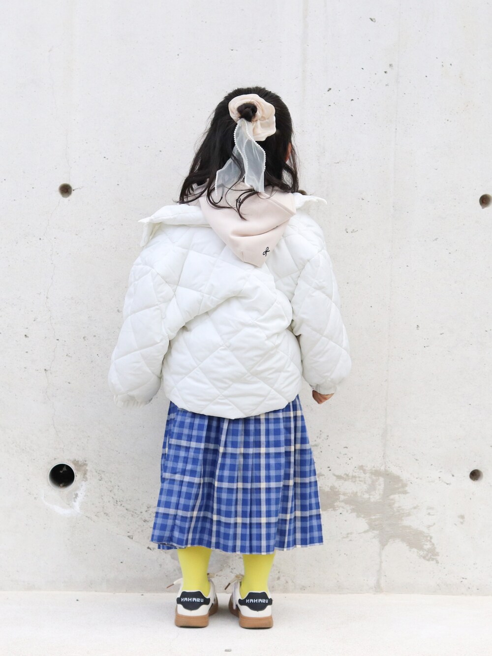 ベージュ系のブルゾン、ホワイト系のパーカー、その他のスカートを着用したキッズの冬コーディネートの3枚目の写真