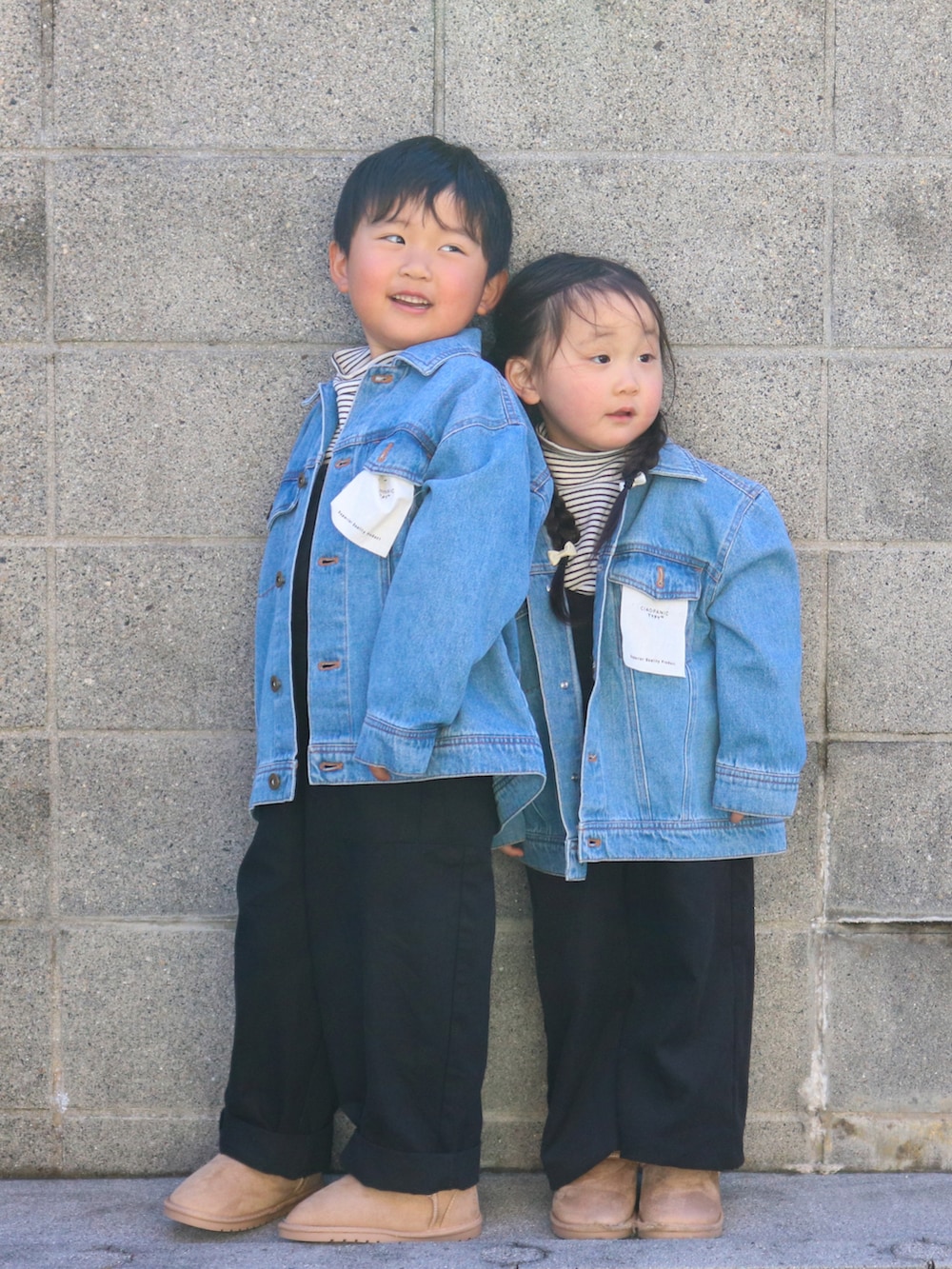 ブルー系のデニムジャケット、ホワイト系のトップス、ブラック系のサロペット/オーバーオールを着用したキッズの冬コーディネートの3枚目の写真