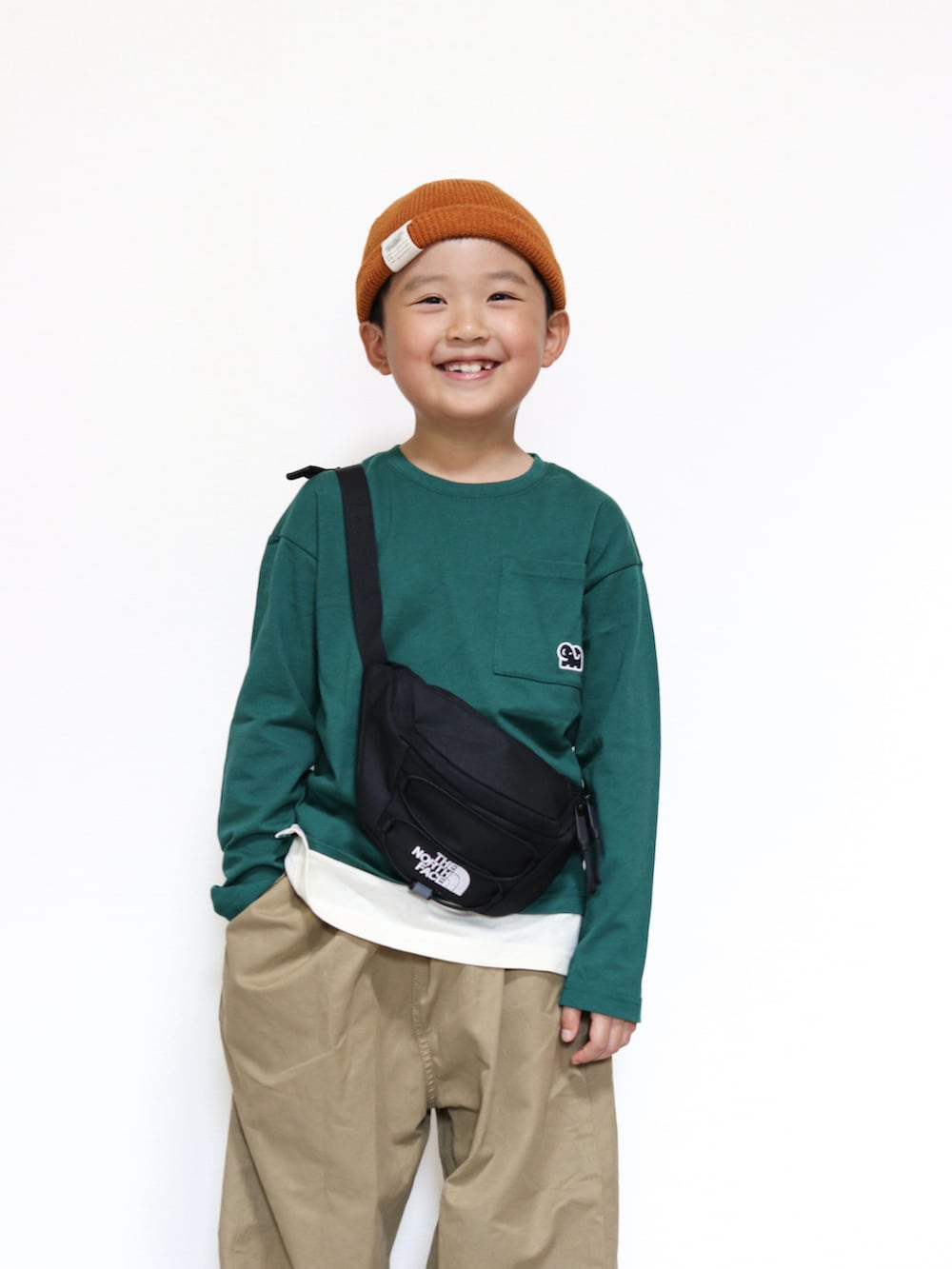 ホワイト系のスニーカー、グリーン系のTシャツ/カットソー、ベージュ系のその他パンツを着用したキッズの秋コーディネートの3枚目の写真