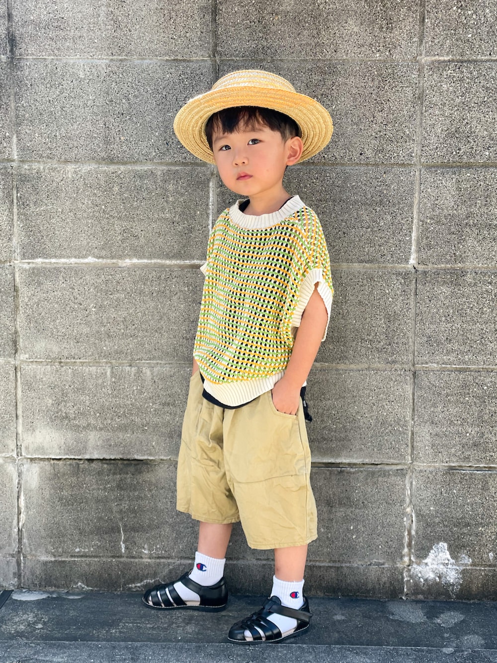 グリーン系のベスト、ブラック系のタンクトップ、ベージュ系のパンツを着用したキッズの夏コーディネートの4枚目の写真