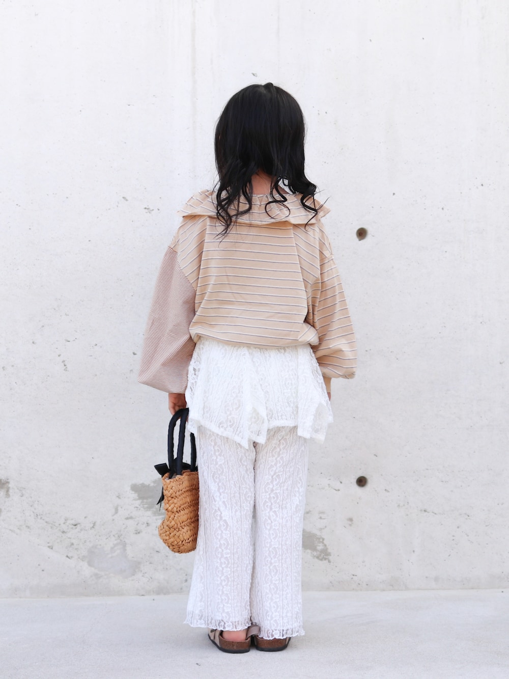 ホワイト系のその他パンツ、ベージュ系のTシャツ/カットソー、ブラック系のかごバッグを着用したキッズの春コーディネートの5枚目の写真