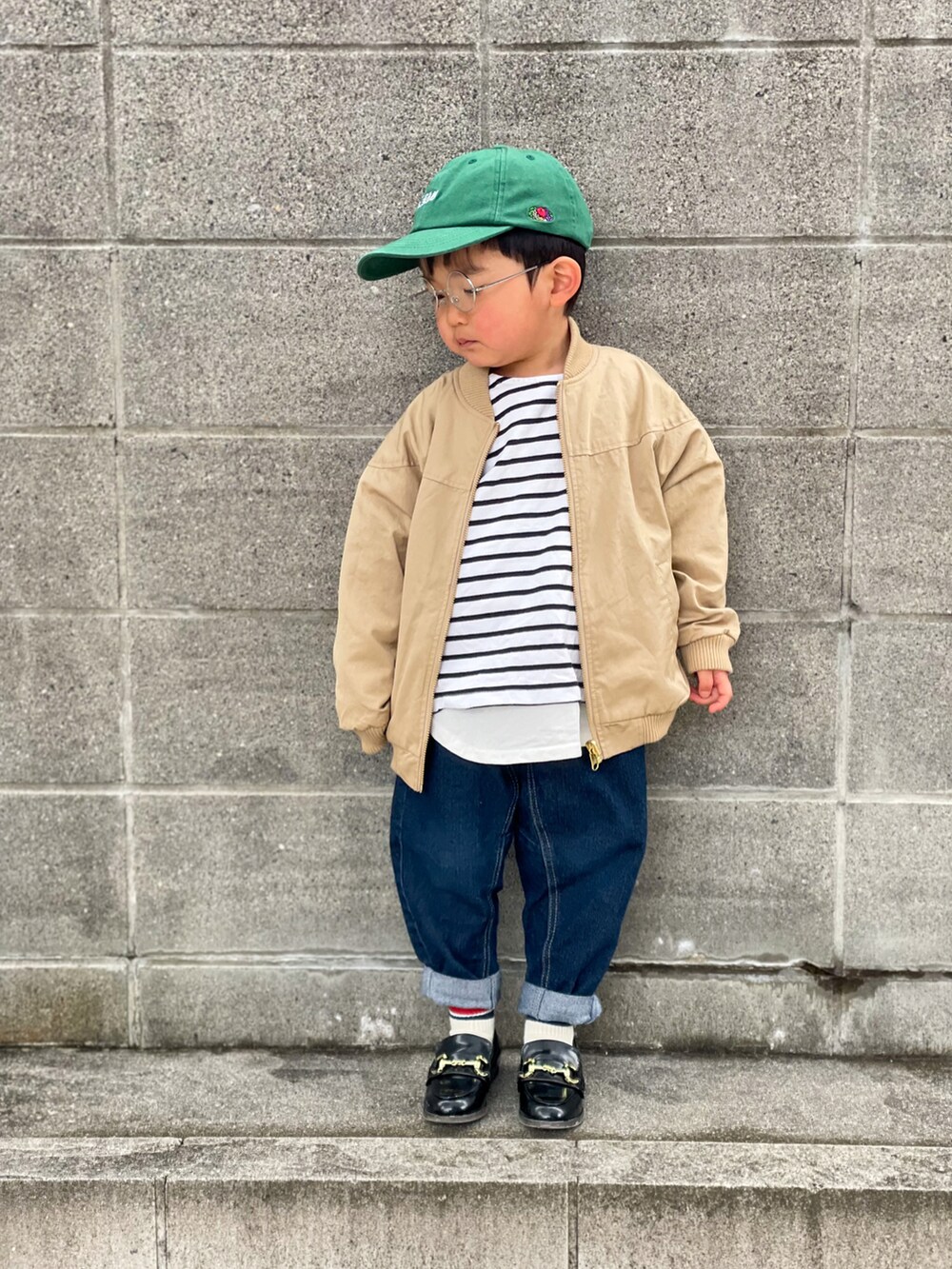 ベージュ系のブルゾン、ブラック系のTシャツ/カットソー、ホワイト系のTシャツ/カットソーを着用したキッズの春コーディネートの2枚目の写真