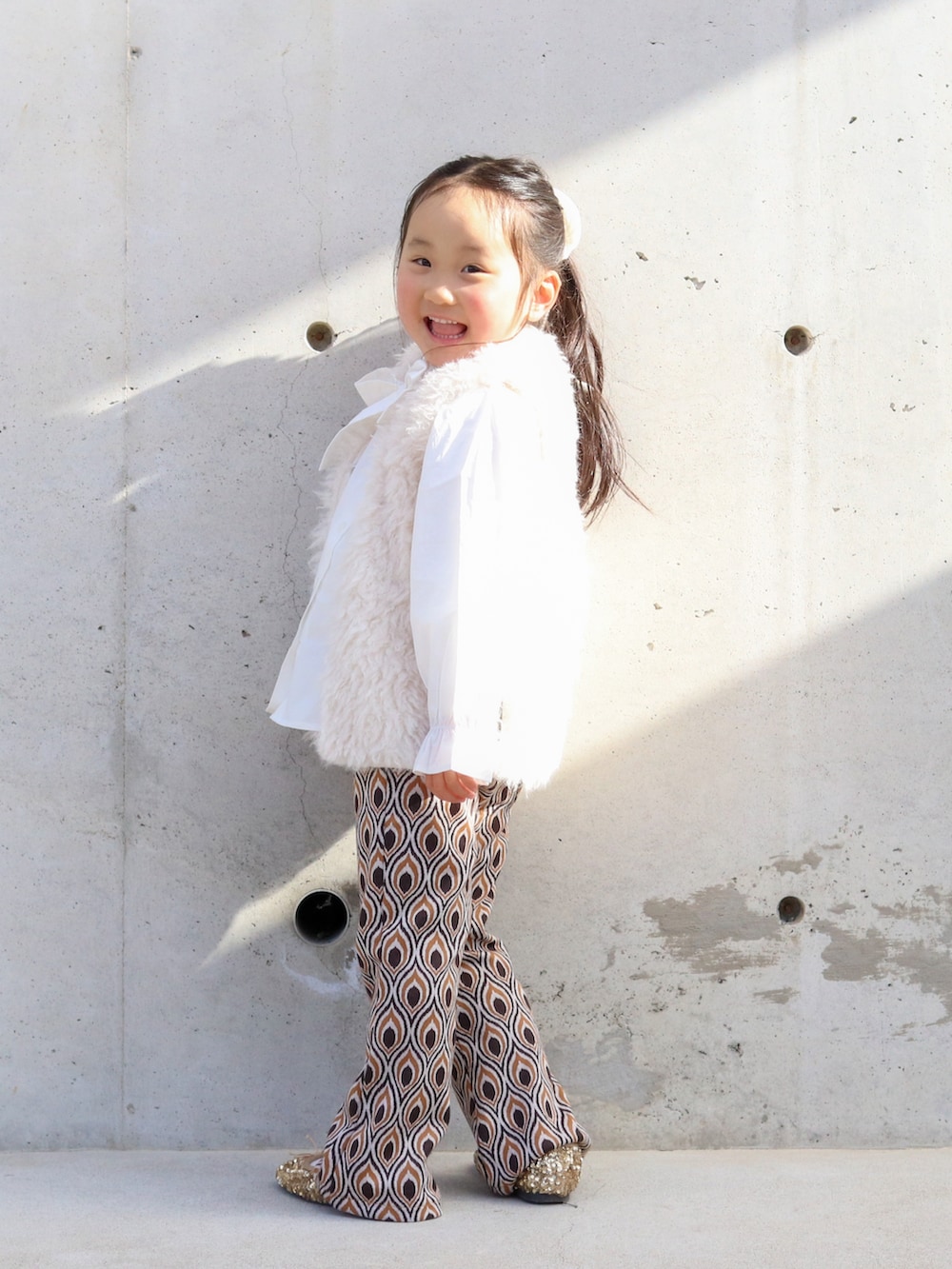 ホワイト系のシャツ/ブラウス、ホワイト系のベスト、ブラウン系のスウェットパンツを着用したキッズの冬コーディネートの3枚目の写真