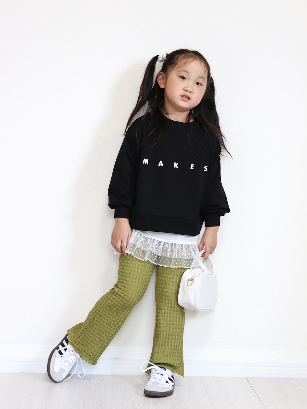 ホワイト系のショルダーバッグ、ホワイト系のスニーカー、ブラック系のTシャツ/カットソーを着用したキッズの秋コーディネートの2枚目の写真