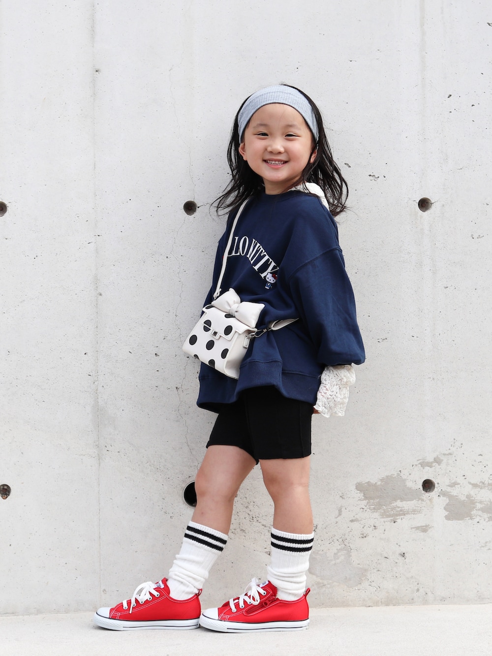 レッド系のスニーカー、ブルー系のスウェット、ホワイト系のTシャツ/カットソーを着用したキッズの秋コーディネートの2枚目の写真