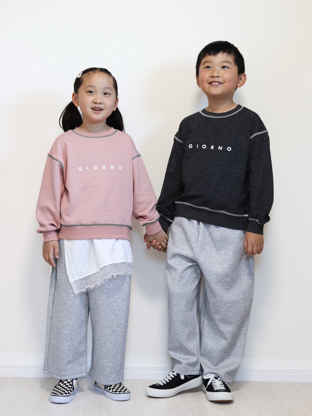 ピンク系のパーカー、ホワイト系のTシャツ/カットソー、グレー系のスウェットパンツを着用したキッズの秋コーディネートの2枚目の写真