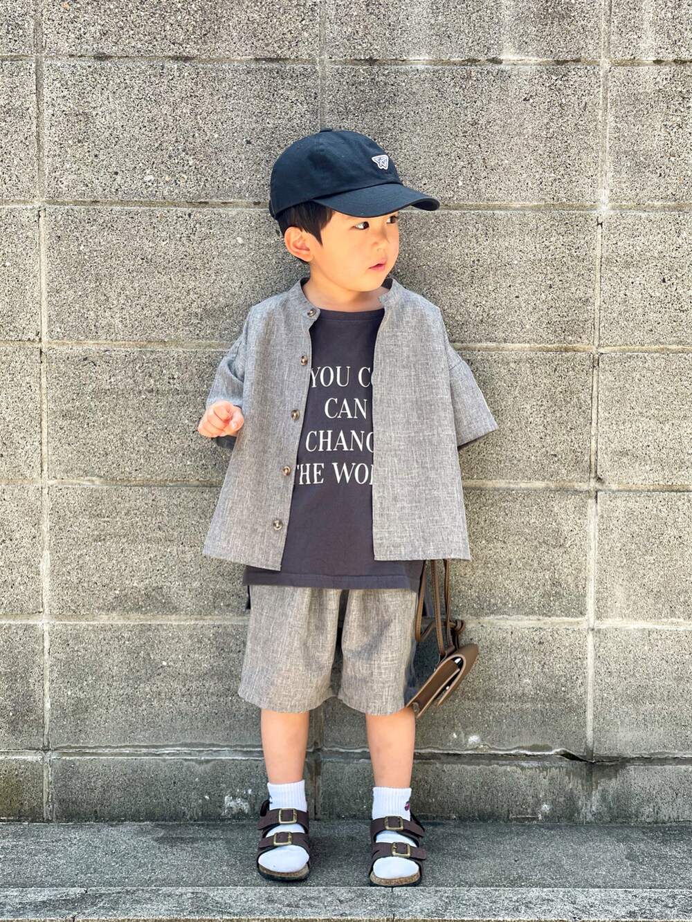グレー系のトップス、グレー系のTシャツ/カットソー、ブラウン系のサンダルを着用したキッズの春コーディネートの3枚目の写真