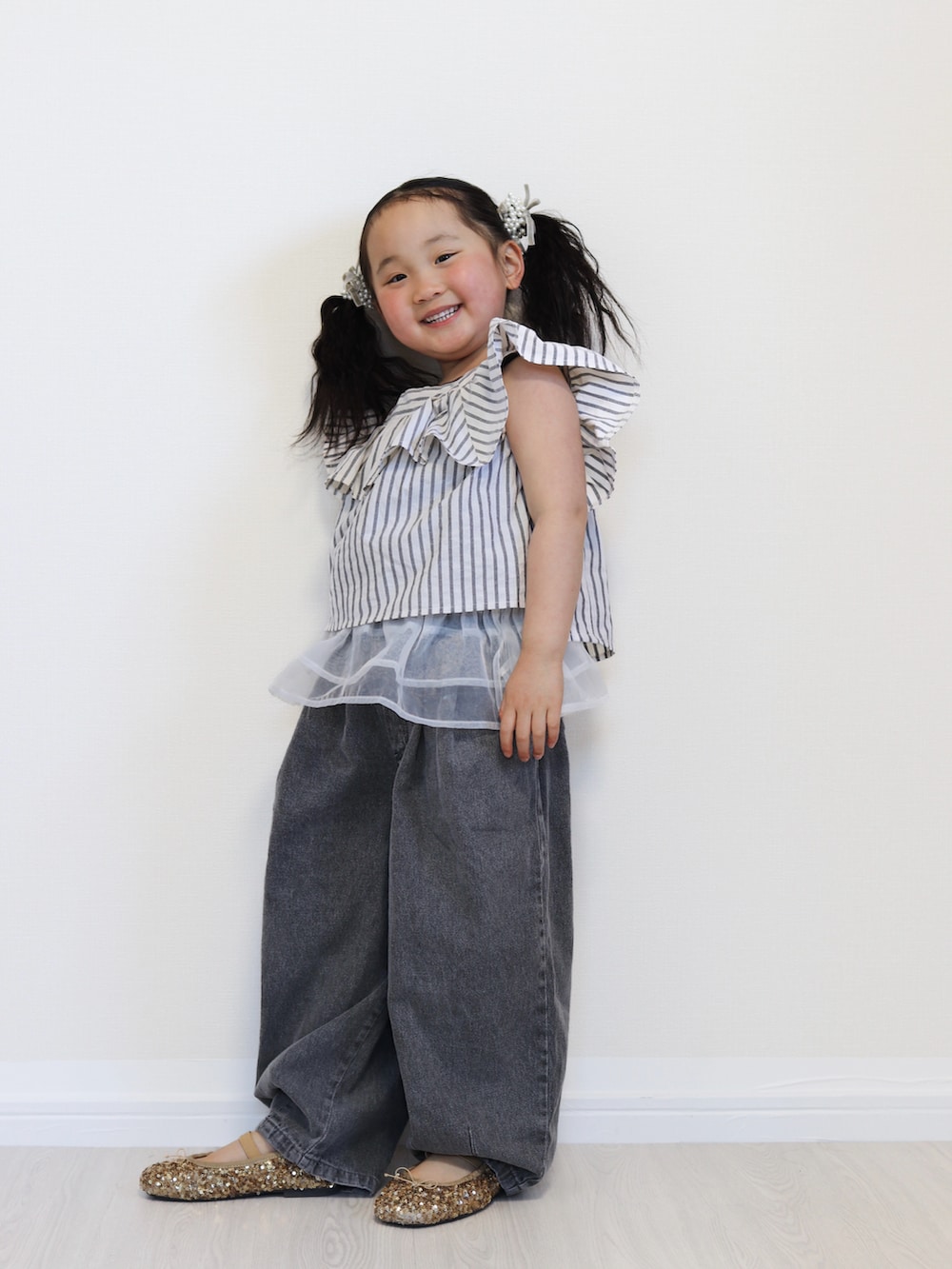 ブラック系のセットアップ、ブラック系のデニムパンツ、ゴールド系のバレエシューズを着用したキッズの春コーディネートの3枚目の写真