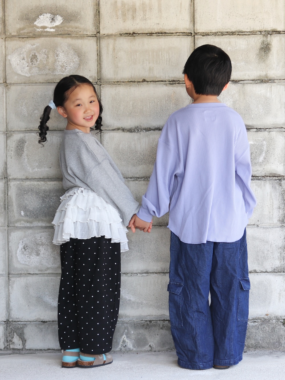 ブルー系のカーゴパンツ、ブルー系のボディバッグ/ウエストポーチ、ベージュ系のサンダルを着用したキッズの春コーディネートの3枚目の写真