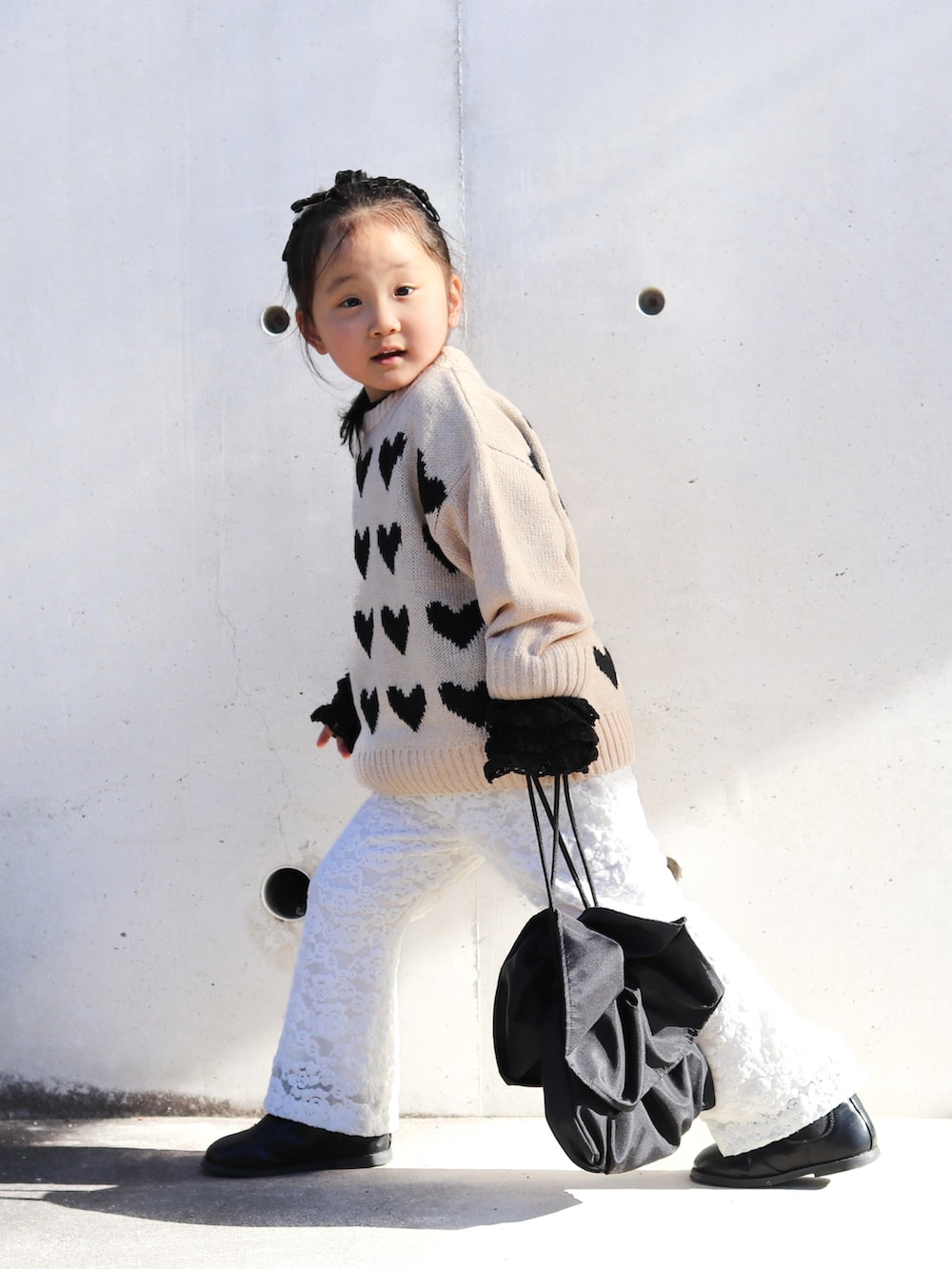 ベージュ系のニット/セーター、ブラック系のTシャツ/カットソー、ホワイト系のその他パンツを着用したキッズの秋コーディネートの3枚目の写真