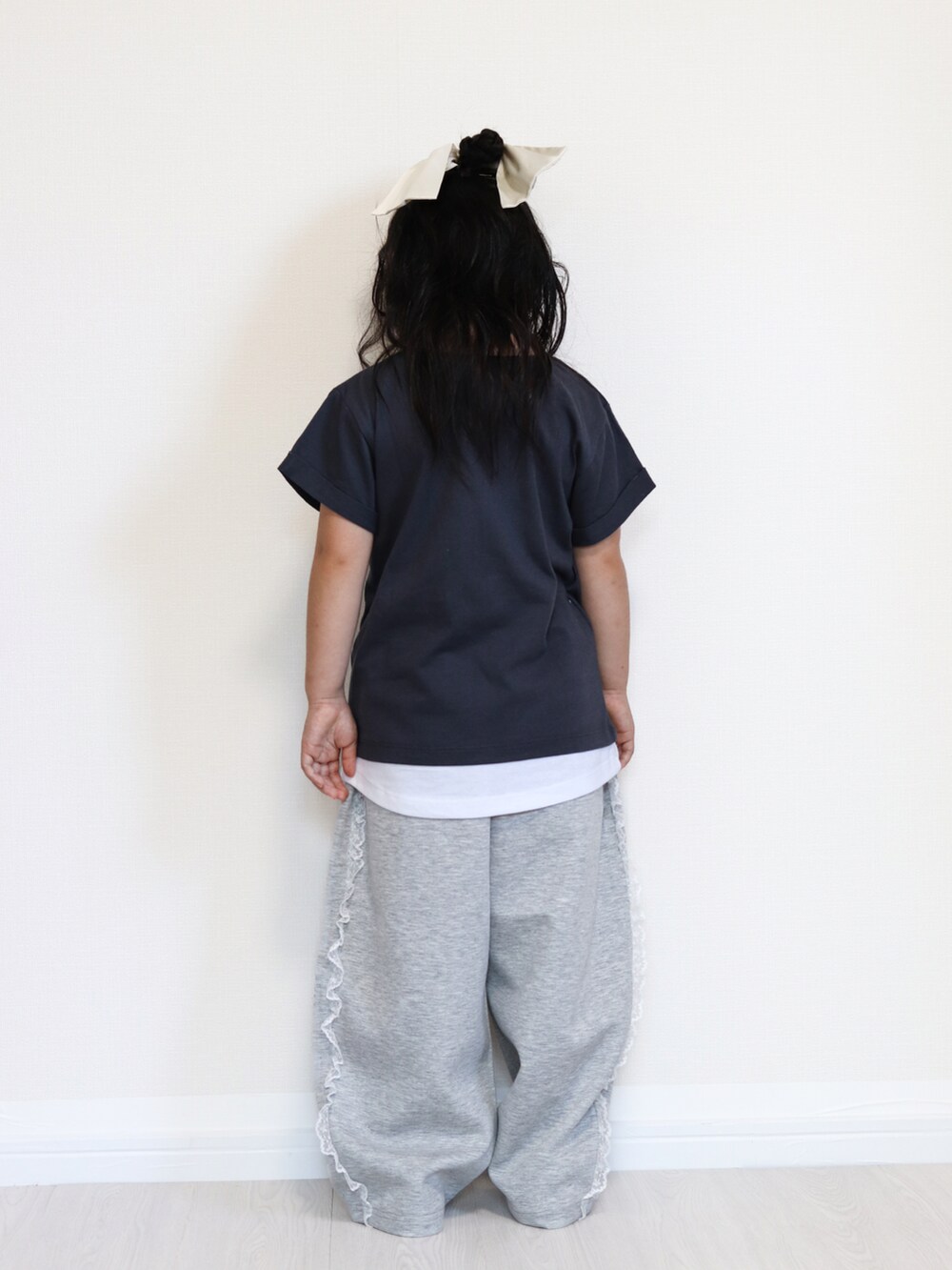 グレー系のTシャツ/カットソー、グレー系のスウェットパンツ、ブラック系のスニーカーを着用したキッズの秋コーディネートの5枚目の写真