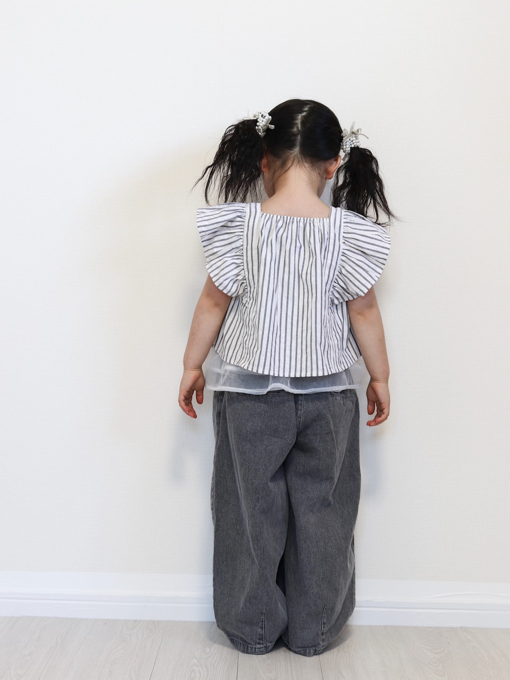 ブラック系のセットアップ、ブラック系のデニムパンツ、ゴールド系のバレエシューズを着用したキッズの春コーディネートの4枚目の写真