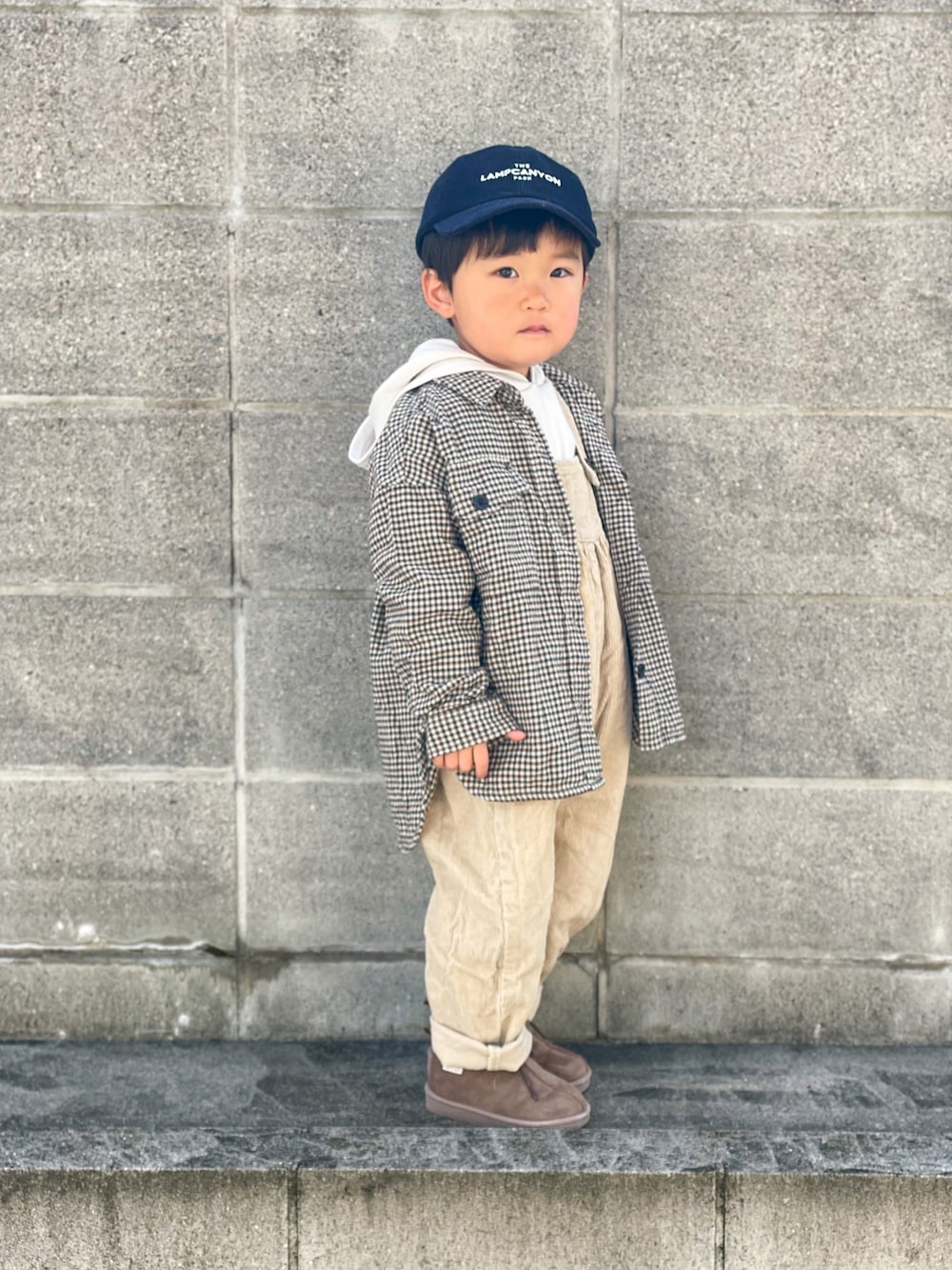 ホワイト系のパーカー、ベージュ系のサロペット/オーバーオール、ベージュ系のシャツ/ブラウスを着用したキッズの秋コーディネートの3枚目の写真