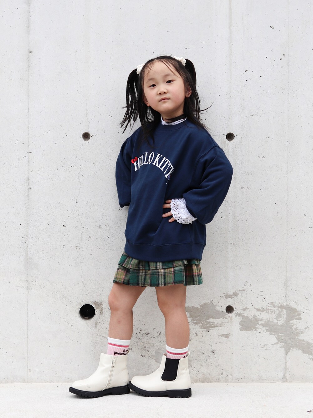 ホワイト系のTシャツ/カットソー、ホワイト系のブーツ、グリーン系のスカートを着用したキッズの秋コーディネートの2枚目の写真