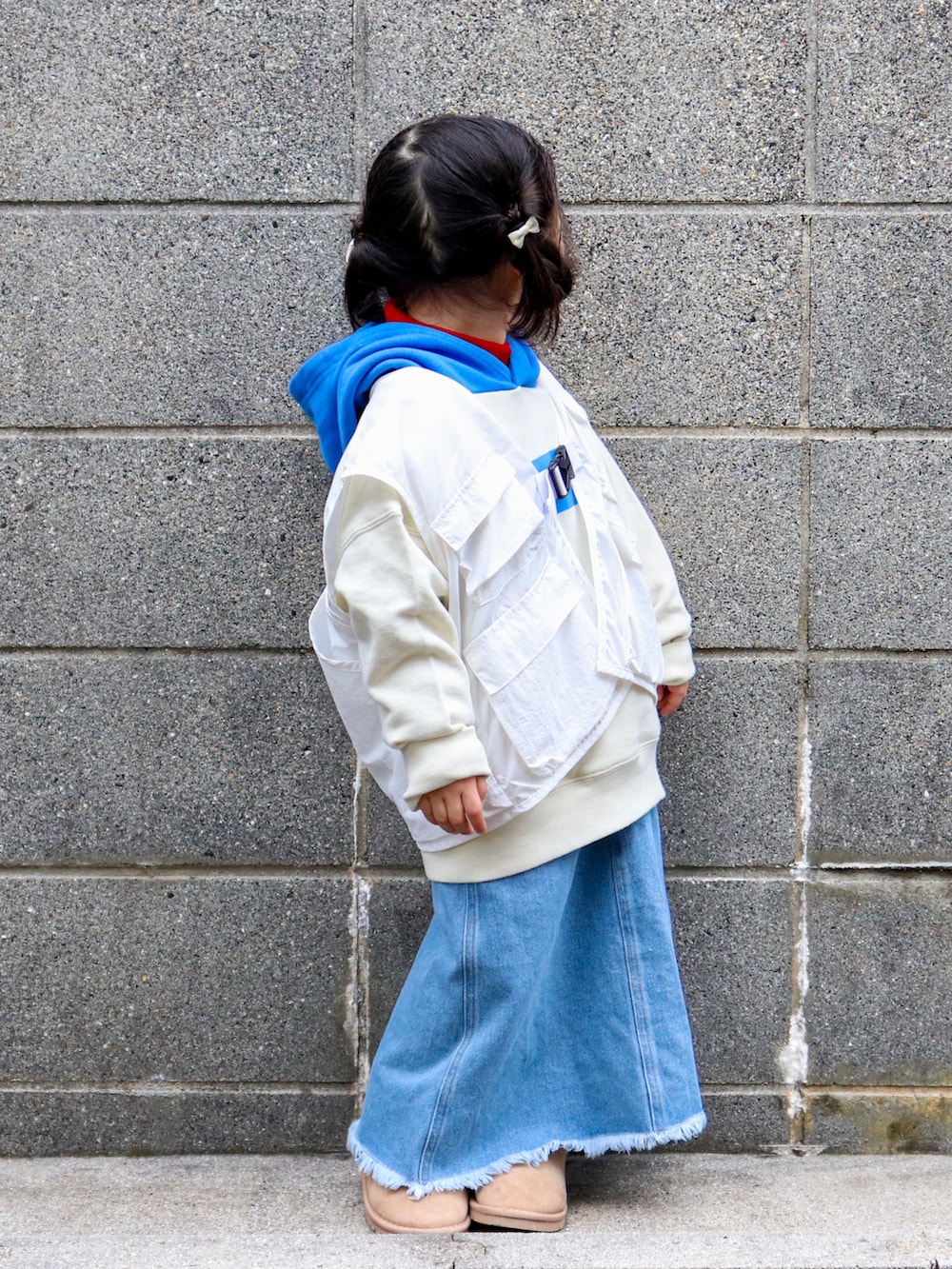 ホワイト系のパーカー、レッド系のニット/セーター、ホワイト系のベストを着用したキッズの冬コーディネートの2枚目の写真