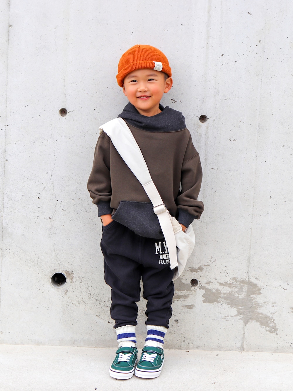 グリーン系のスウェット、ブラック系のその他パンツ、ホワイト系のショルダーバッグを着用したキッズの秋コーディネートの4枚目の写真