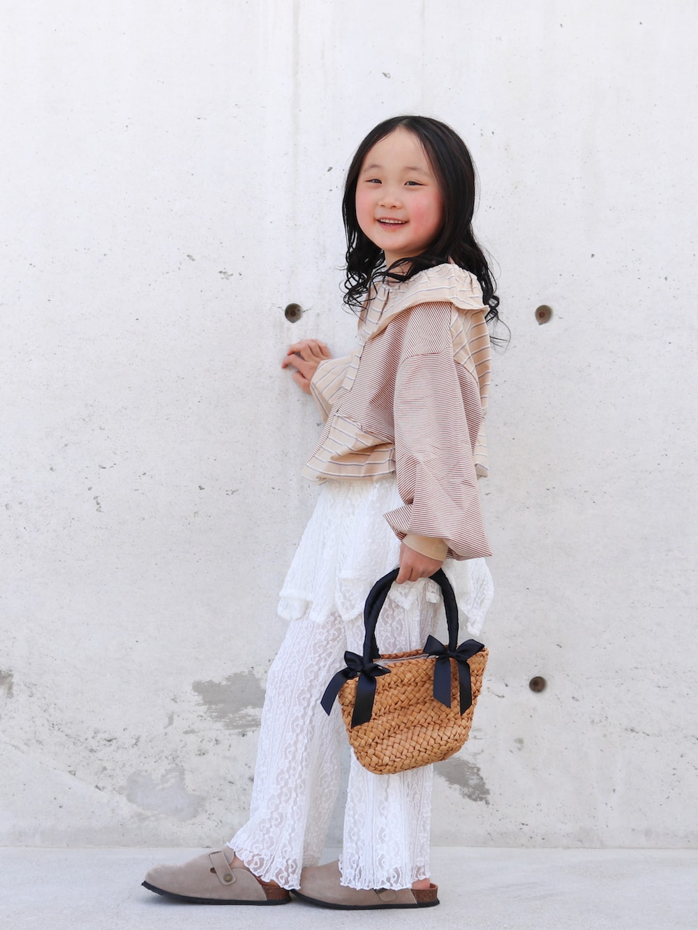 ホワイト系のその他パンツ、ベージュ系のTシャツ/カットソー、ブラック系のかごバッグを着用したキッズの春コーディネートの4枚目の写真