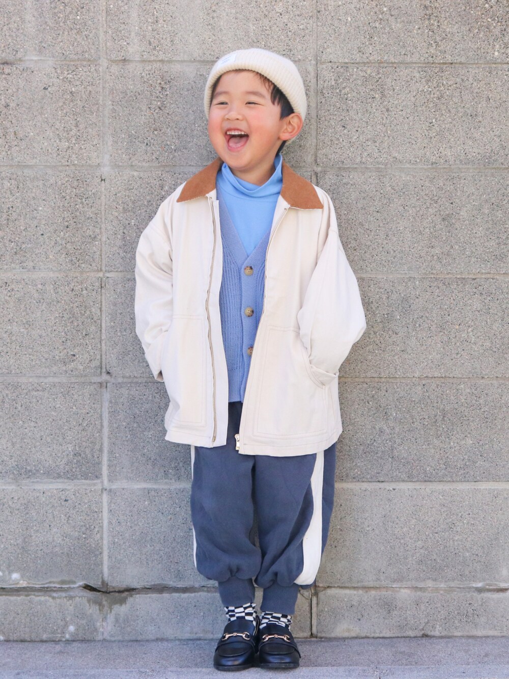ホワイト系のミリタリージャケット、ホワイト系のカーディガン/ボレロ、ブルー系のTシャツ/カットソーを着用したキッズの冬コーディネートの2枚目の写真