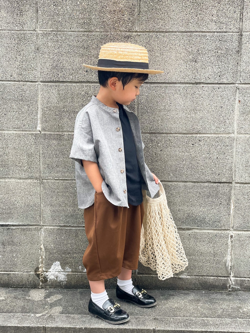 グレー系のトップス、ブラック系のタンクトップ、ブラウン系のパンツを着用したキッズの夏コーディネートの2枚目の写真