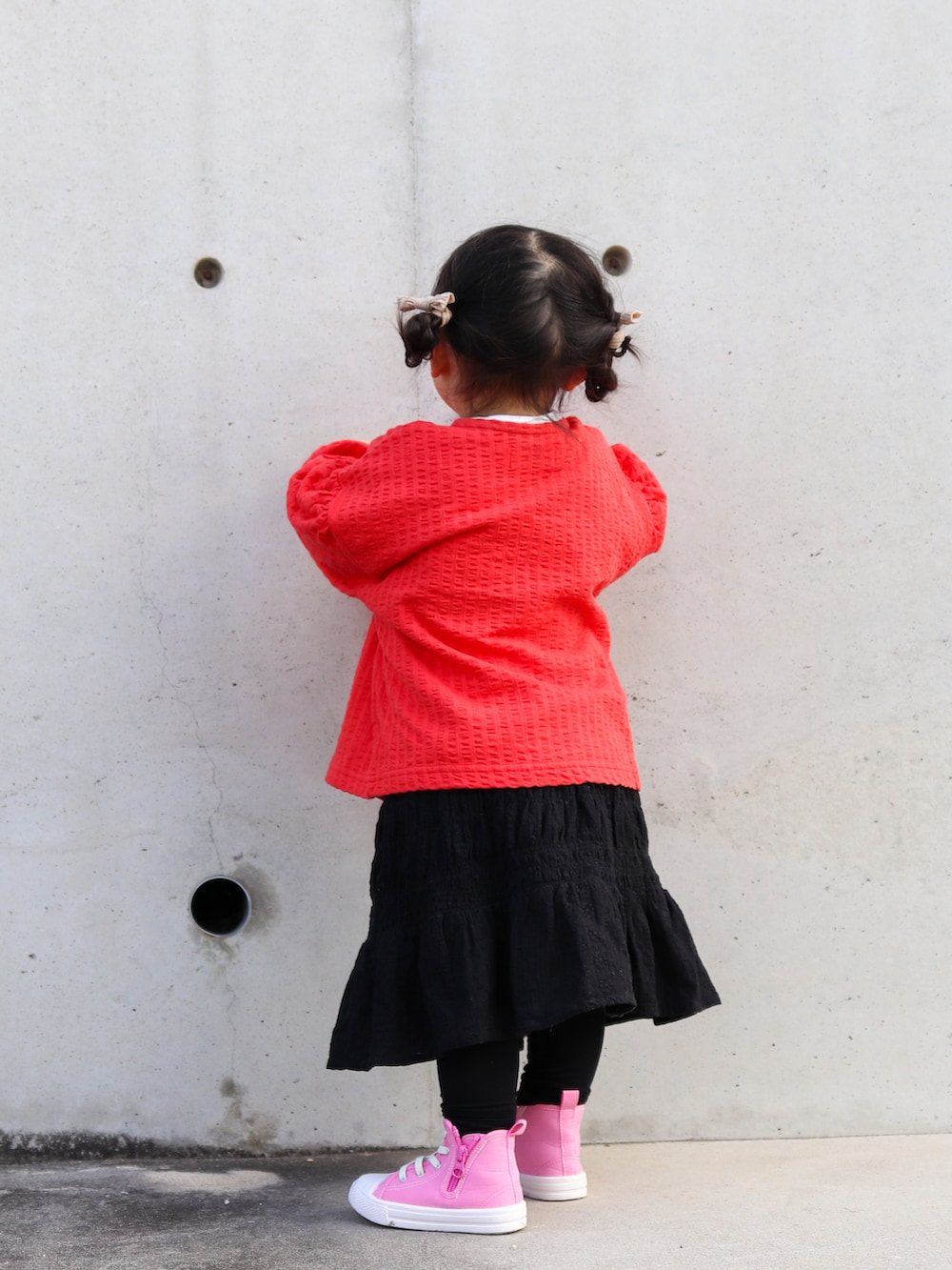 レッド系のカーディガン/ボレロ、ホワイト系のシャツ/ブラウス、ブラック系のスカートを着用したキッズの冬コーディネートの4枚目の写真